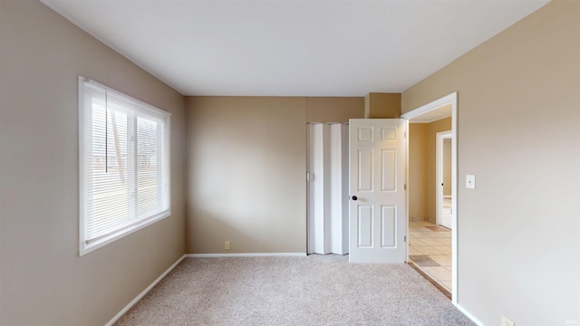 unfurnished bedroom with light carpet and baseboards