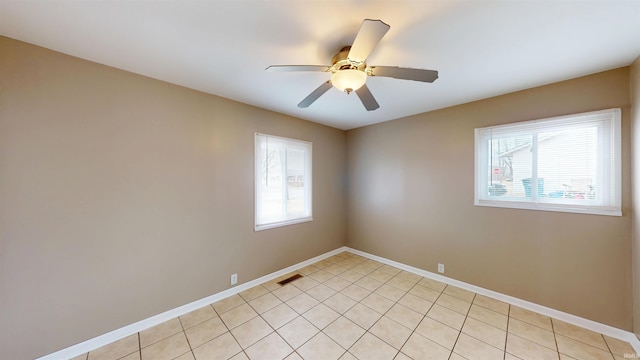 unfurnished room with a ceiling fan, visible vents, baseboards, and light tile patterned floors