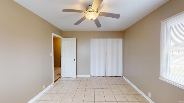 unfurnished bedroom with light tile patterned floors, multiple windows, and baseboards