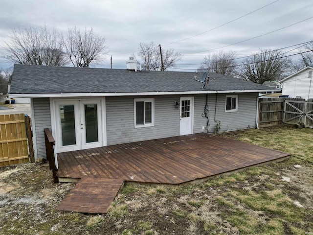 rear view of house featuring french doors, roof with shingles, fence, and a wooden deck