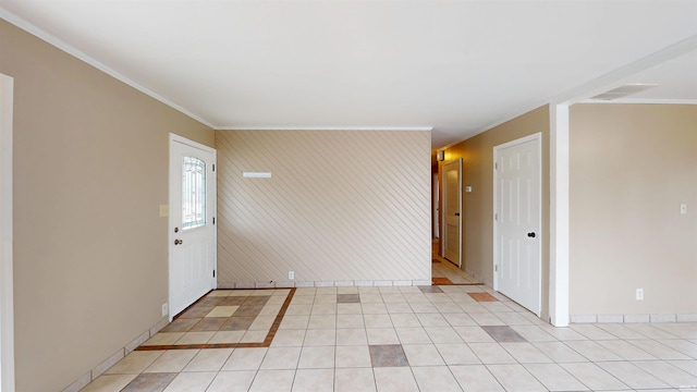 foyer with light tile patterned floors, baseboards, and crown molding