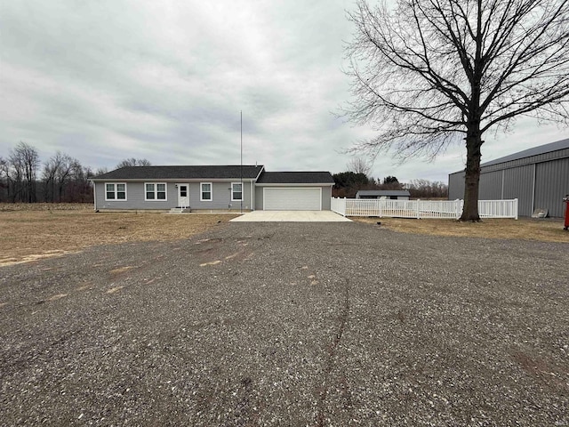 view of front of property with driveway, a garage, and fence