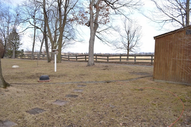 view of yard with fence and a rural view