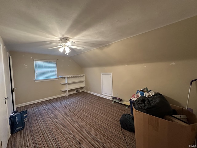 bonus room with vaulted ceiling, dark colored carpet, ceiling fan, and baseboards