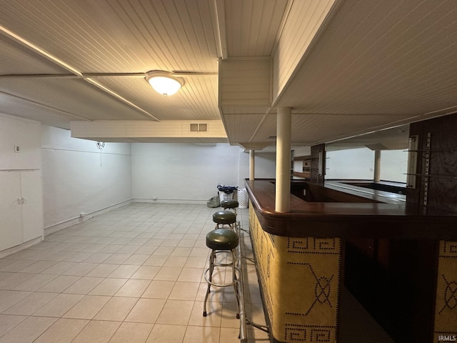 bar with light tile patterned flooring, visible vents, and baseboards