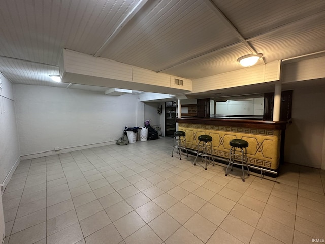 bar featuring a dry bar, baseboards, visible vents, and tile patterned floors