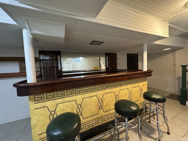 bar featuring a bar and tile patterned flooring