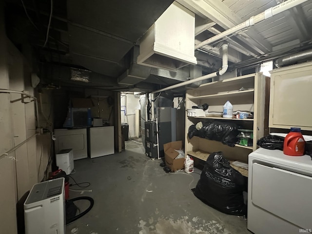 unfinished basement with refrigerator, washer / dryer, and heating unit