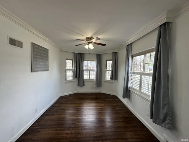 empty room featuring dark wood-style floors, ornamental molding, visible vents, and a healthy amount of sunlight