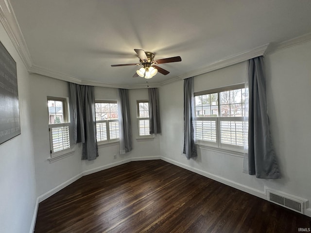 spare room featuring baseboards, visible vents, dark wood finished floors, and ornamental molding