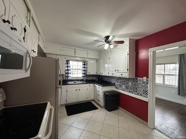 kitchen with light tile patterned floors, a ceiling fan, white cabinetry, a sink, and white appliances