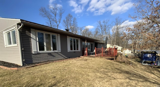 rear view of house with a deck and a lawn