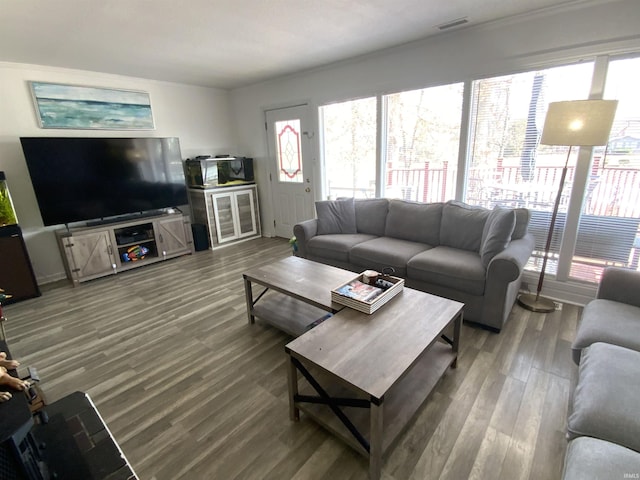 living area with wood finished floors and visible vents