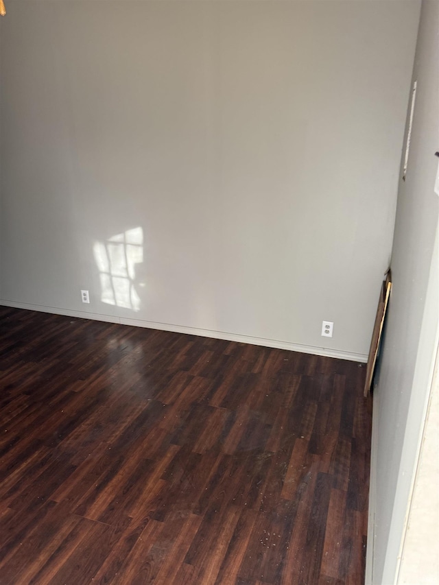 unfurnished room with dark wood-style floors and baseboards