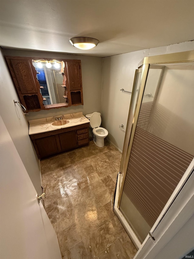 bathroom with toilet, a stall shower, and vanity