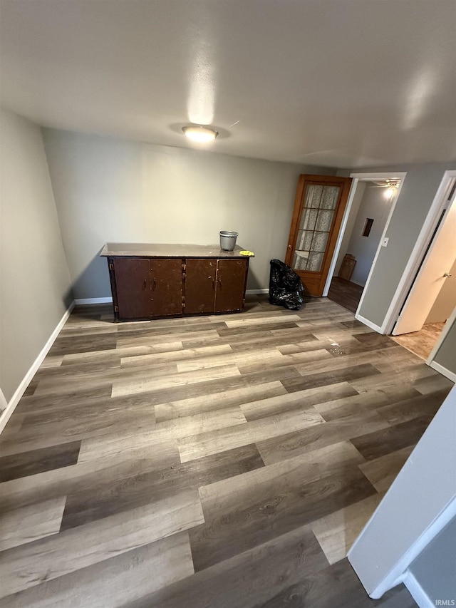 spare room featuring baseboards and wood finished floors