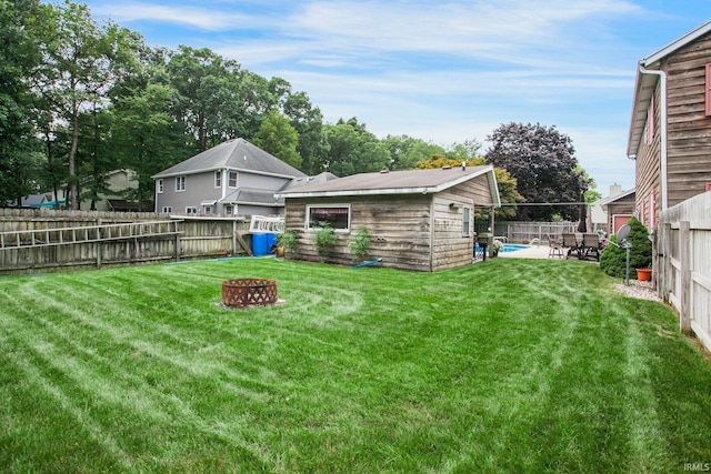 view of yard featuring a patio area, a fenced backyard, and a fire pit