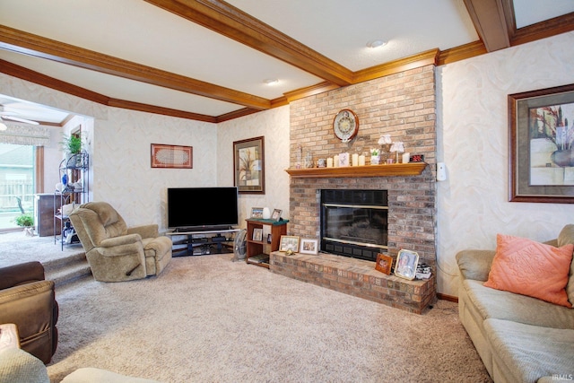 living room with carpet, a fireplace, ornamental molding, a ceiling fan, and beamed ceiling