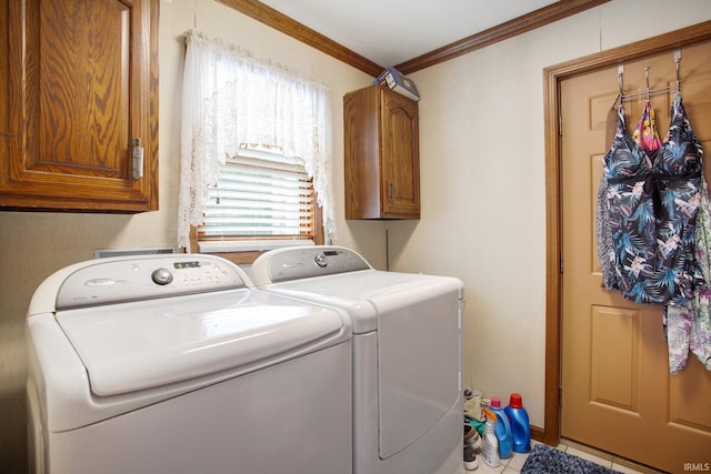 clothes washing area featuring ornamental molding, separate washer and dryer, cabinet space, and tile patterned floors