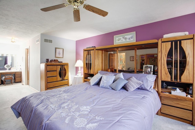 bedroom with baseboards, a textured ceiling, visible vents, and carpet flooring