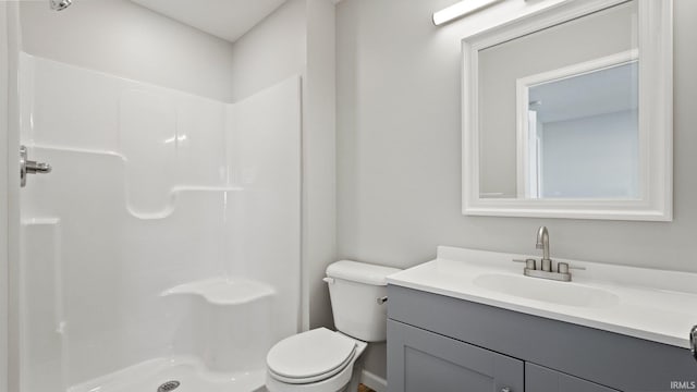 full bath featuring toilet, a shower stall, and vanity