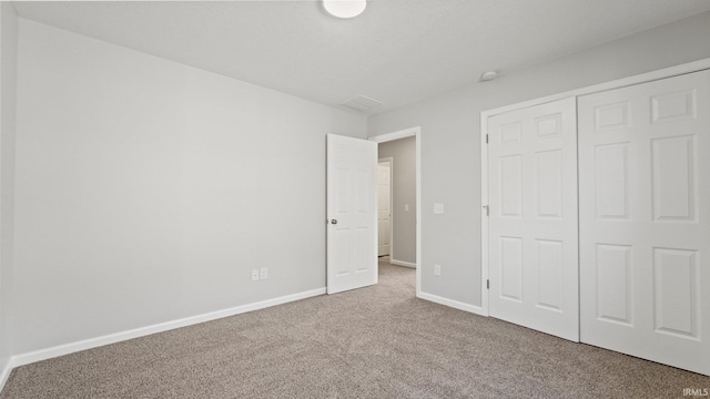 unfurnished bedroom with carpet floors, a closet, and baseboards