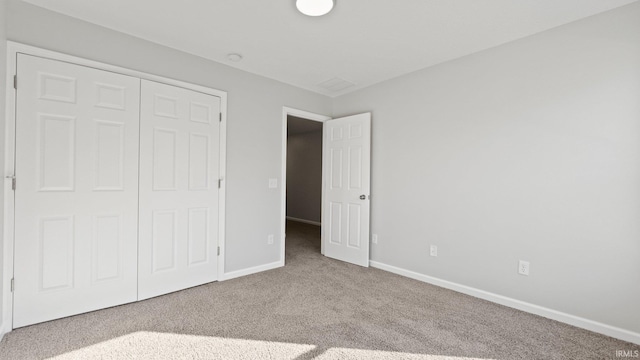 unfurnished bedroom featuring a closet, carpet flooring, and baseboards