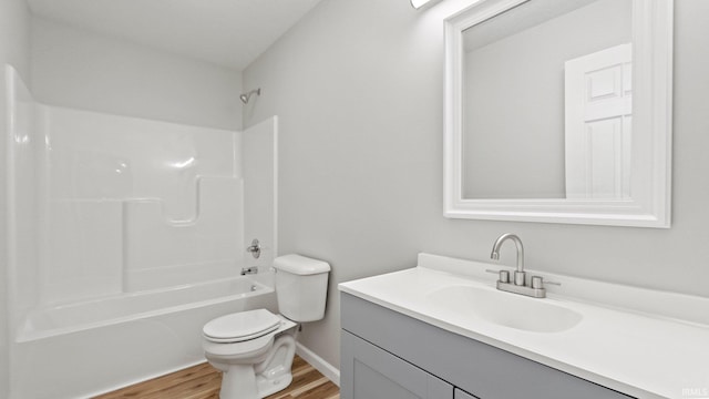 full bathroom with washtub / shower combination, vanity, toilet, and wood finished floors