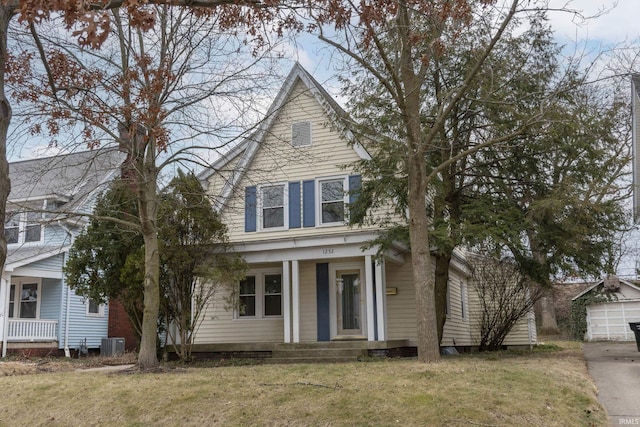 view of front of property featuring covered porch, central AC unit, and a front yard