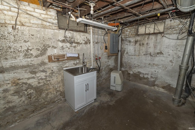 unfinished below grade area featuring electric panel and a sink