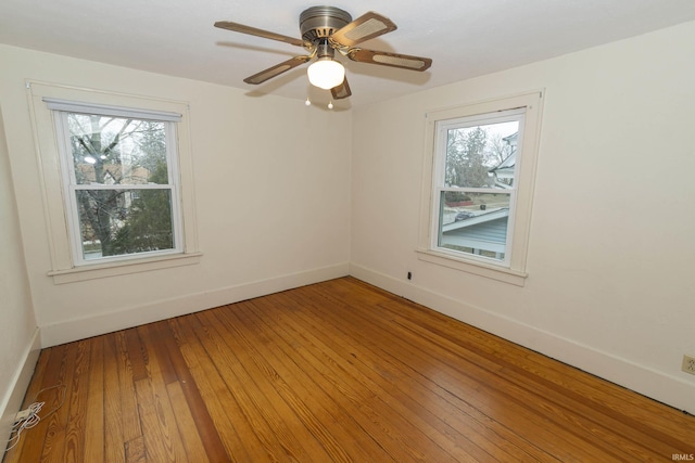 spare room featuring light wood-style floors, baseboards, and a ceiling fan