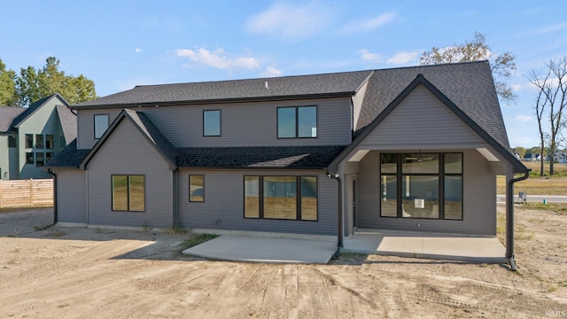 back of property featuring a patio area, a shingled roof, and fence