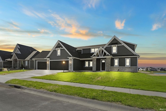 view of front of house with an attached garage, stone siding, driveway, and a front lawn