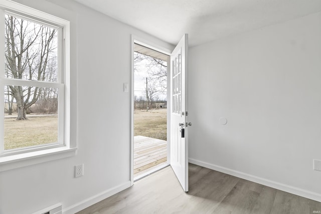 doorway to outside with baseboards and wood finished floors