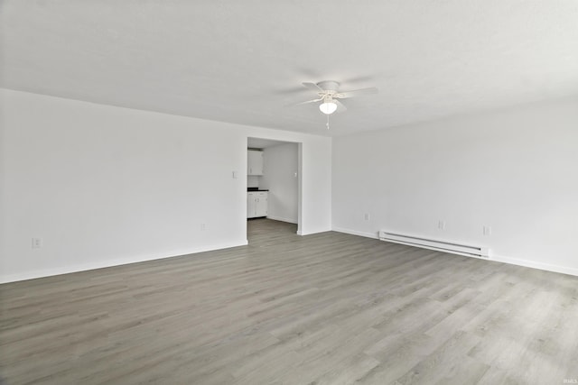 empty room featuring a baseboard radiator, baseboards, ceiling fan, and wood finished floors