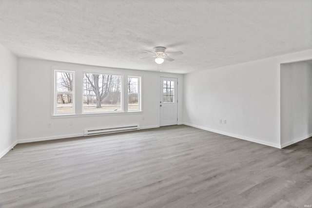 unfurnished living room with ceiling fan, a textured ceiling, a baseboard heating unit, wood finished floors, and baseboards