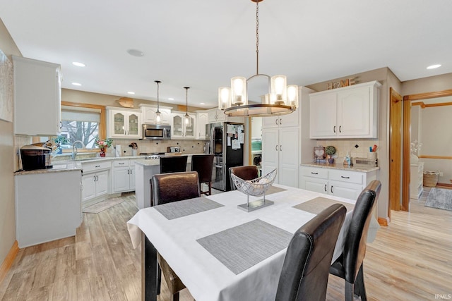 dining room with light wood-type flooring and recessed lighting