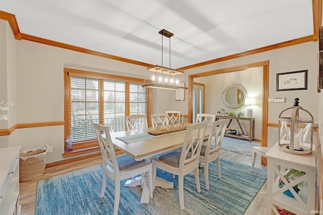 dining space with light wood-style flooring, baseboards, and crown molding