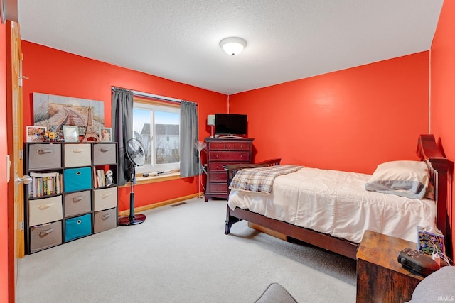 carpeted bedroom featuring visible vents and a textured ceiling