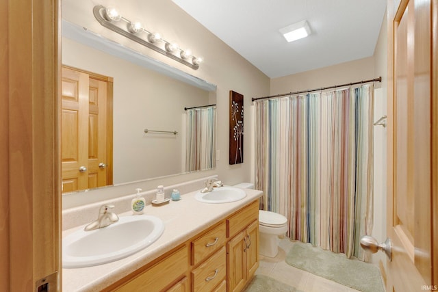 bathroom featuring double vanity, toilet, a sink, and tile patterned floors