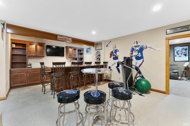 bar featuring light carpet, baseboards, a bar, and recessed lighting