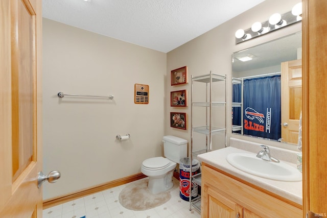 bathroom featuring baseboards, toilet, tile patterned floors, a textured ceiling, and vanity