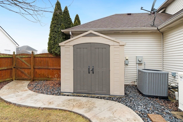 view of shed featuring a gate, central AC, and fence