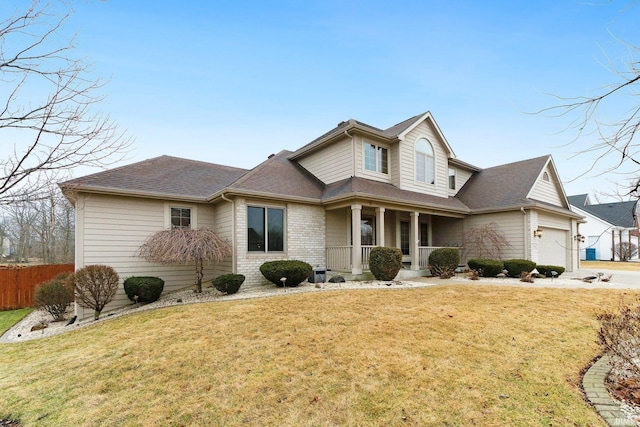 view of front of house with brick siding, covered porch, an attached garage, fence, and a front lawn