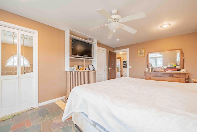 bedroom featuring a ceiling fan, baseboards, stone tile flooring, and recessed lighting