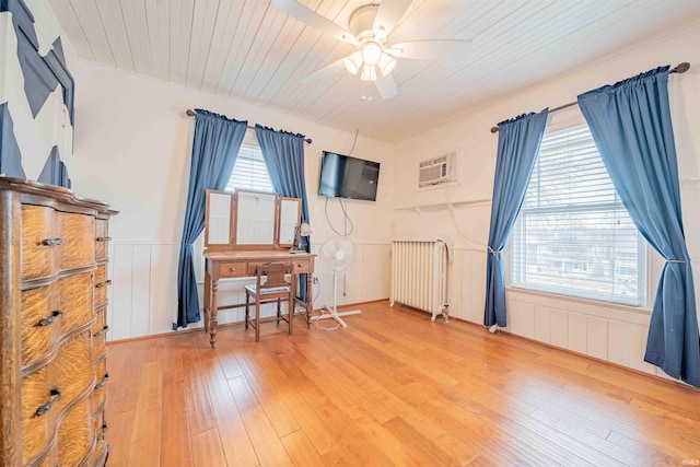 office space with a ceiling fan, a wealth of natural light, radiator, and hardwood / wood-style floors