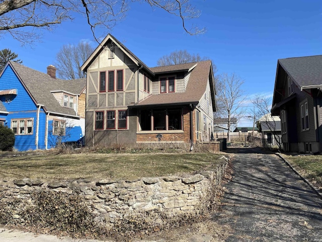 exterior space with brick siding, roof with shingles, and stucco siding