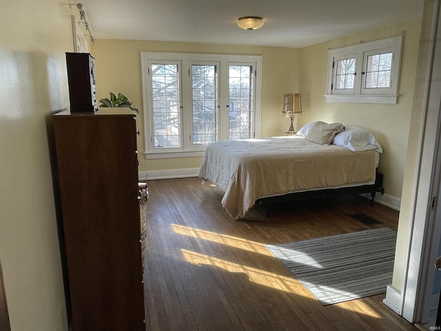 bedroom with dark wood-type flooring and baseboards