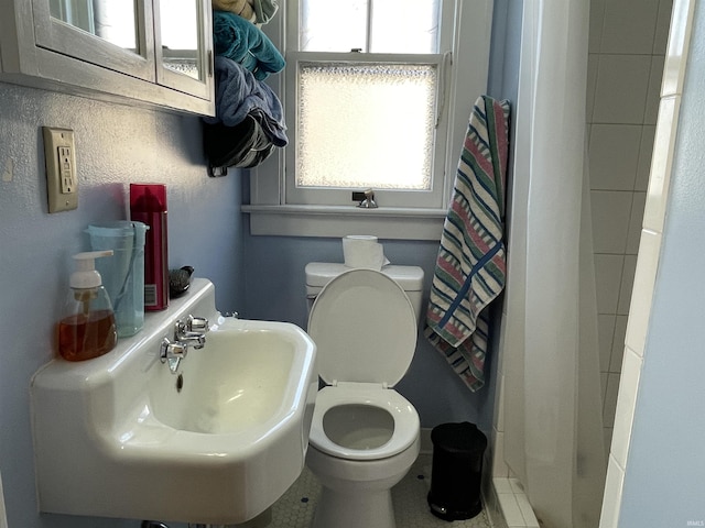 bathroom with a shower with shower curtain, a sink, and toilet