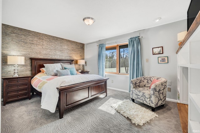 bedroom with an accent wall and baseboards